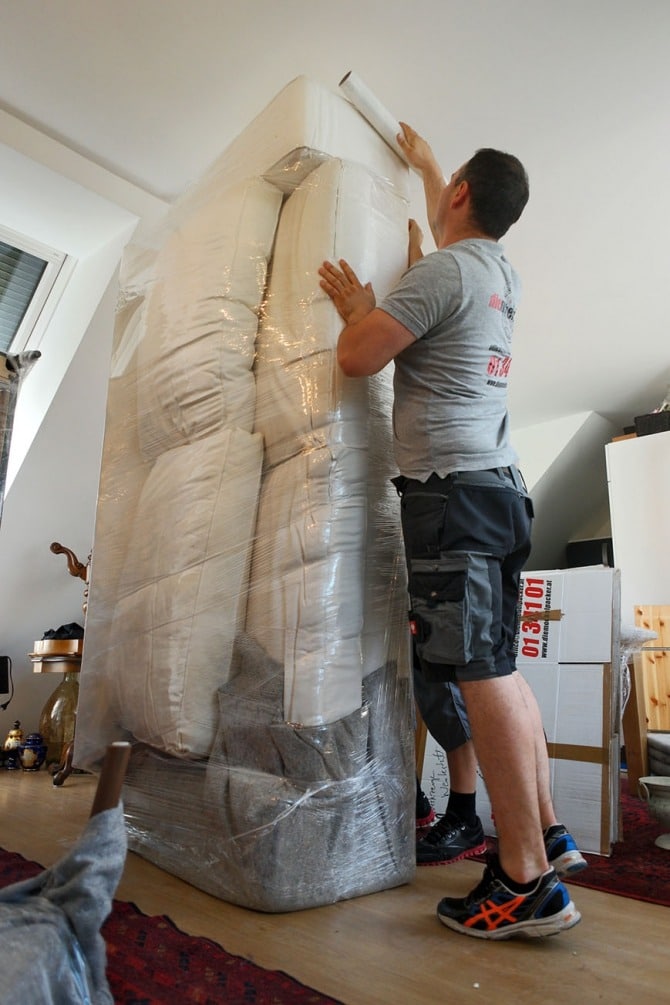 Möberlpacker beim Verpacken von Sofa